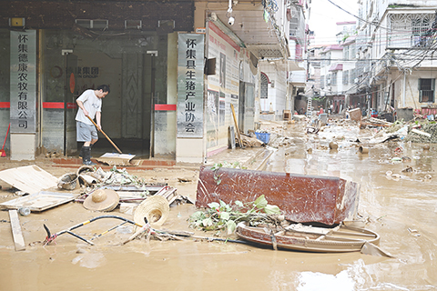 ◎ 六月十九日,廣東省肇慶市懷集縣的居民在清理雜物和淤泥。近日,受颱風「蝴蝶」及高空槽和季風共同影響,懷集縣遭遇持續性強降雨侵襲,江河水位快速上漲,多地出現超警戒洪水及內澇等險情。險情發生後,當地迅速響應,全力進行搶險救災工作。目前,當地洪水已逐步退去,各方救援人員清淤泥、通水電、通道路,爭分奪秒開展災後救援。(中新社記者陳楚紅 攝)