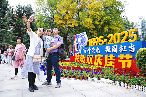 校友在天津大學衛津路校區北洋園與建校130周年主題標識合影。(中新社記者 佟郁 攝)