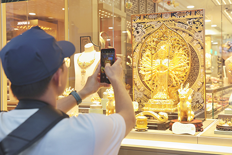 ◎ 十月六日,顧客被櫥窗內的黃金飾品吸引。隨著美國聯邦政府停擺持續,香港時間當日金價再創新高,逼近每盎司四千美元大關。(香港中通社記者 謝光磊 攝)