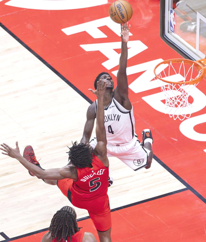 ◎ 十一月二十三日,籃網隊球員保維(上)上籃。多倫多速龍隊主場一百一十九比一百零九戰勝布魯克林籃網隊。(新華社發 鄒崢攝)