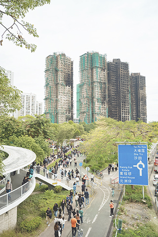 ◎ 十一月三十日,大批香港民眾自發前往大埔宏福苑火災現場,在警戒線外排隊獻花,悼念火災罹難者。(中新社記者 侯宇 攝)