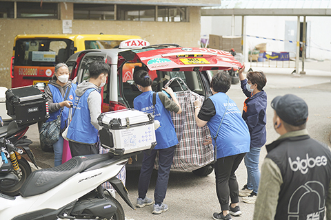 ◎ 十二月三日,大埔宏福苑大火中唯一未被波及的宏志閣,昨早在政府安排下,居民陸續返回家中收拾個人物品。每戶可以返回大廈一次,限兩人同時上樓,逗留最多一個半小時。圖為義載的士接載居民離開。(香港中通社 陳奕啟 攝)