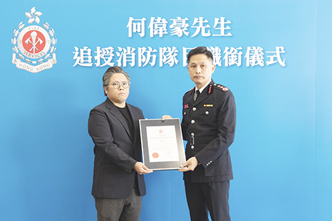 ◎ 十二月十一日,香港特區政府消防處向在大埔宏福苑火災救援行動中殉職的何偉豪追授消防隊目榮譽職銜。圖為消防處處長楊恩健(右)頒授追授函件,由何偉豪家人代表接受。(香港特區政府新聞處供圖)