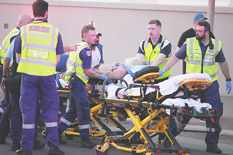 ◎ 十二月十四日,緊急救援人員在雪梨邦迪海灘發生槍擊事件後,用擔架運送一名人員。(美聯社照片/馬克·貝克)