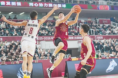 ◎ 十二月十八日,山西隊球員張寧(紅)上籃。在太原進行的CBA常規賽第三輪比賽中,山西汾酒隊主場以一百零二比九十一戰勝浙江稠州金租隊。(中新社記者武俊傑 攝)