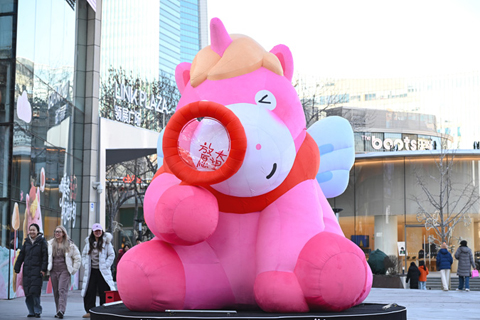 ◎ 一月五日,市民走過北京街頭一處馬元素裝飾。(中新社記者 田雨昊 攝)