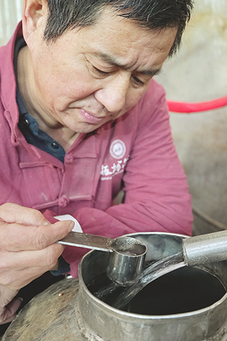 ◎ 一月二十八日,河北省承德縣承德乾隆醉酒業有限責任公司的工人在釀酒車間查看新釀酒的酒花。(新華社記者楊世堯 攝)