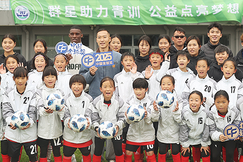 ◎ 三月二日,中國金球獎足球公益活動在南京舉行,上海申花足球俱樂部運動員吳曦、北京國安足球俱樂部運動員法比奧走進南京市足球運動學校,與足球青訓隊員交流互動。圖為法比奧、吳曦與南京的球員們合影。(中新社記者 泱波 攝)