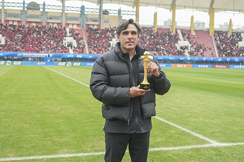 ◎ 三月十五日,中國足球超級聯賽第二輪比賽中,河南俱樂部彩陶坊隊主場二比一勝雲南玉昆隊。圖為比賽前河南俱樂部彩陶坊隊主教練丹尼爾.拉莫斯領取二0二五賽季中超年度最佳教練員獎杯。(中新社記者范曉恒 攝)