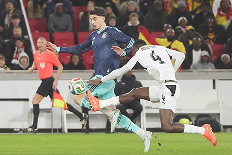 ◎ 三月三十日,德國隊功臣夏維斯(中)和加納隊球員阿傑迪在比賽中拼搶。(新華社發)