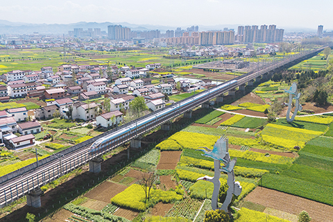 ◎ 高鐵列車駛過洋縣洋州街道何家村附近的朱䴉雕塑(三月卅一日攝,無人機照片)。(新華社記者鄒競一 攝)
