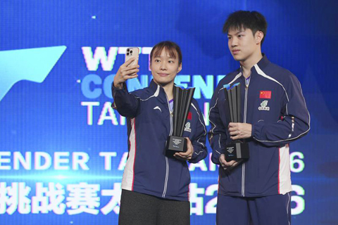 ◎ 四月十一日,混雙冠軍中國組合黃友政(右)/石洵瑤在頒獎儀式上自拍留念。(新華社記者 楊晨光 攝)