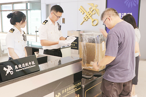 ◎ 中山港海關關員在中山客運口岸離境退稅點為旅客辦理海關驗核業務(成書儀 攝)